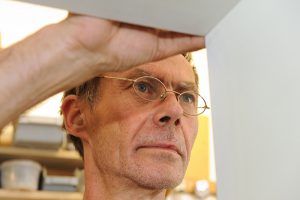 Henk Bosman monteert een plank in zijn werkplaats